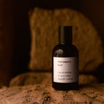 CLAY eau de parfum 50ml against a clay wall