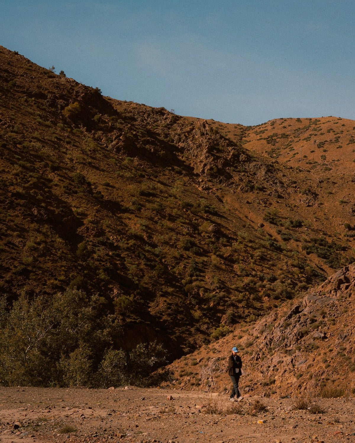 A wide arid valley with a figure on the track