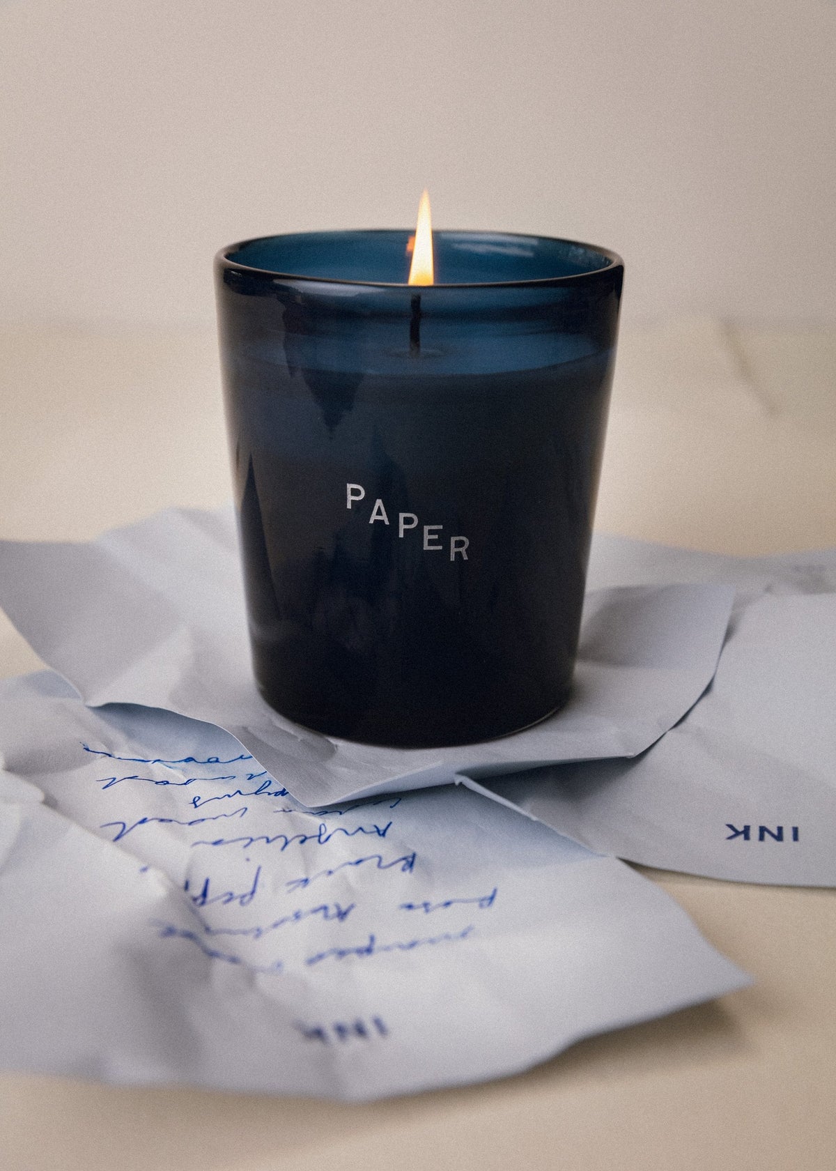 The Paper candle, lit, on handwritten letters