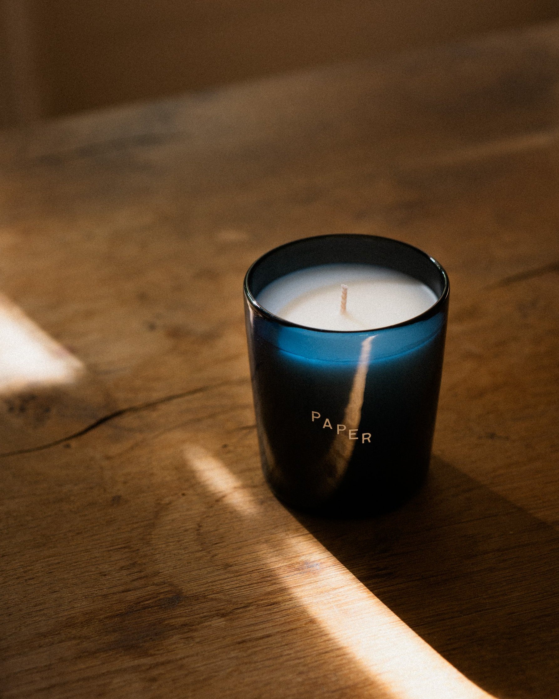 The Paper candle in late light on a wooden table