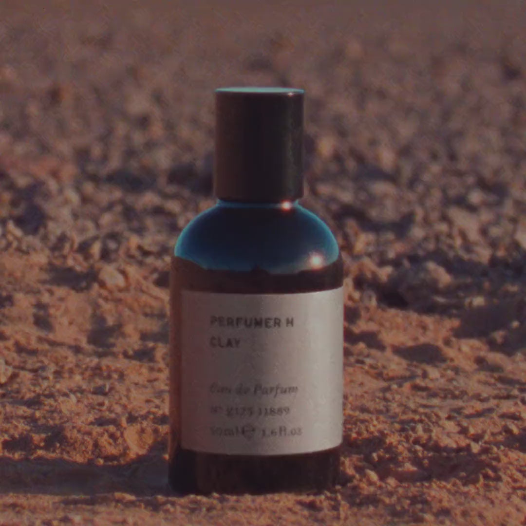 The Clay 50ml eau de parfum standing on red earth in low sun