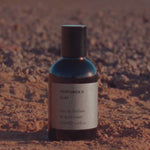 The Clay 50ml eau de parfum standing on red earth in low sun