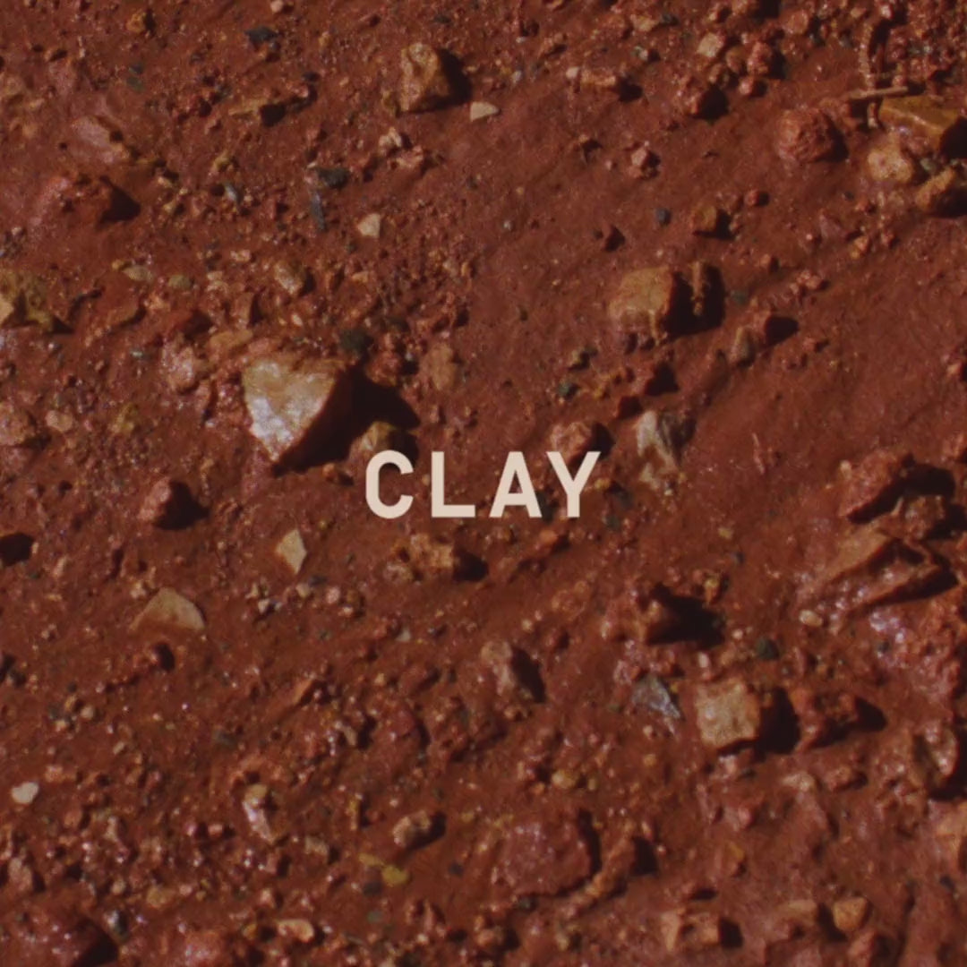 Wet red clay, close, with the CLAY wordmark
