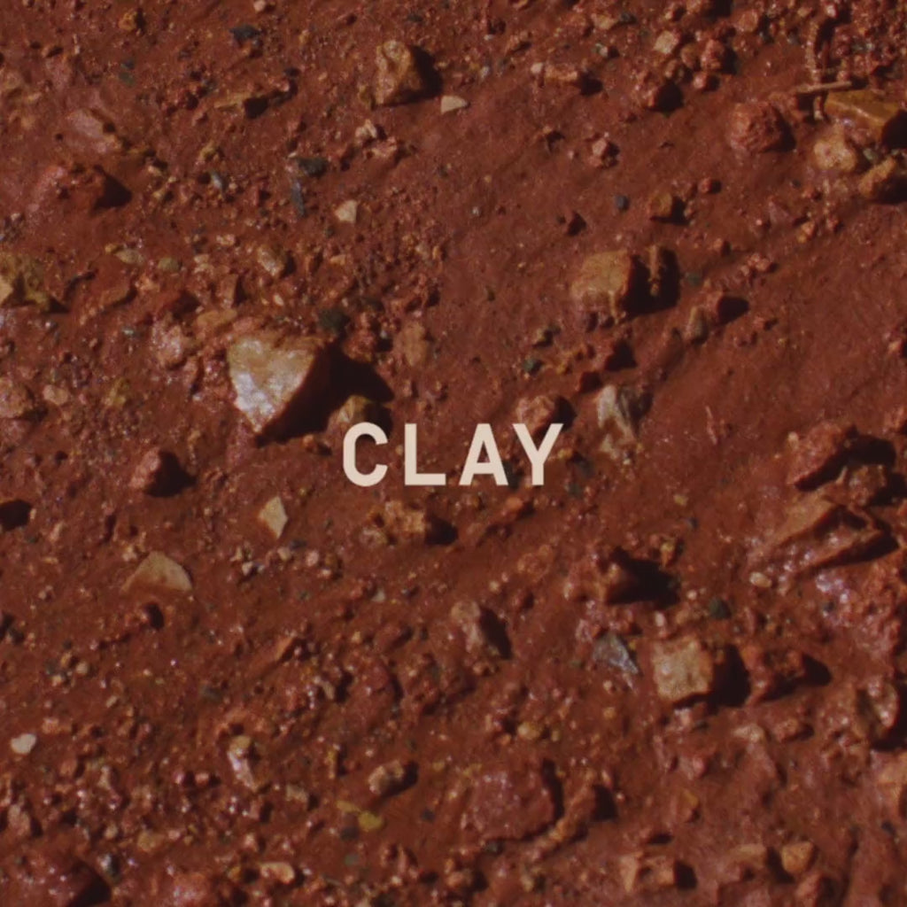 Wet red clay, close, with the CLAY wordmark