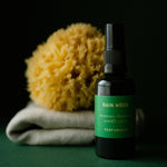 Rain Wood Deodorant bottle with a natural sea sponge and folded oatmeal linen towel
