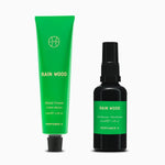 Rain Wood Hand Cream in its green aluminium tube beside the Rain Wood Deodorant in its black glass bottle with a green label